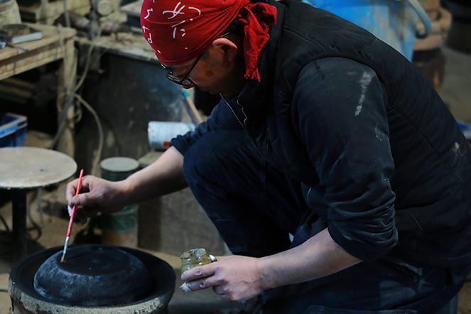 芦屋釜に色を塗る男性職人