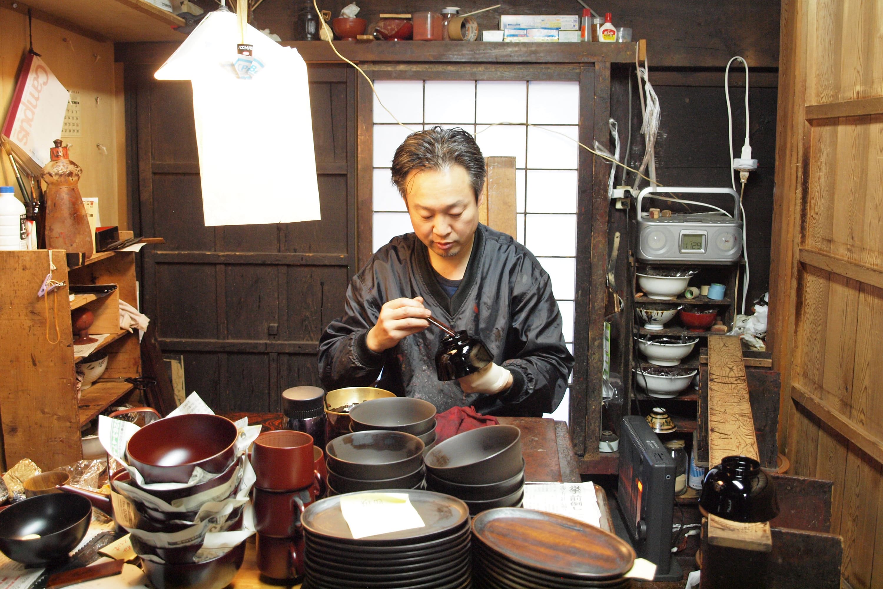 伝統工芸士が木曽漆器を下塗り、中塗り、上塗りと塗り重ねている様子