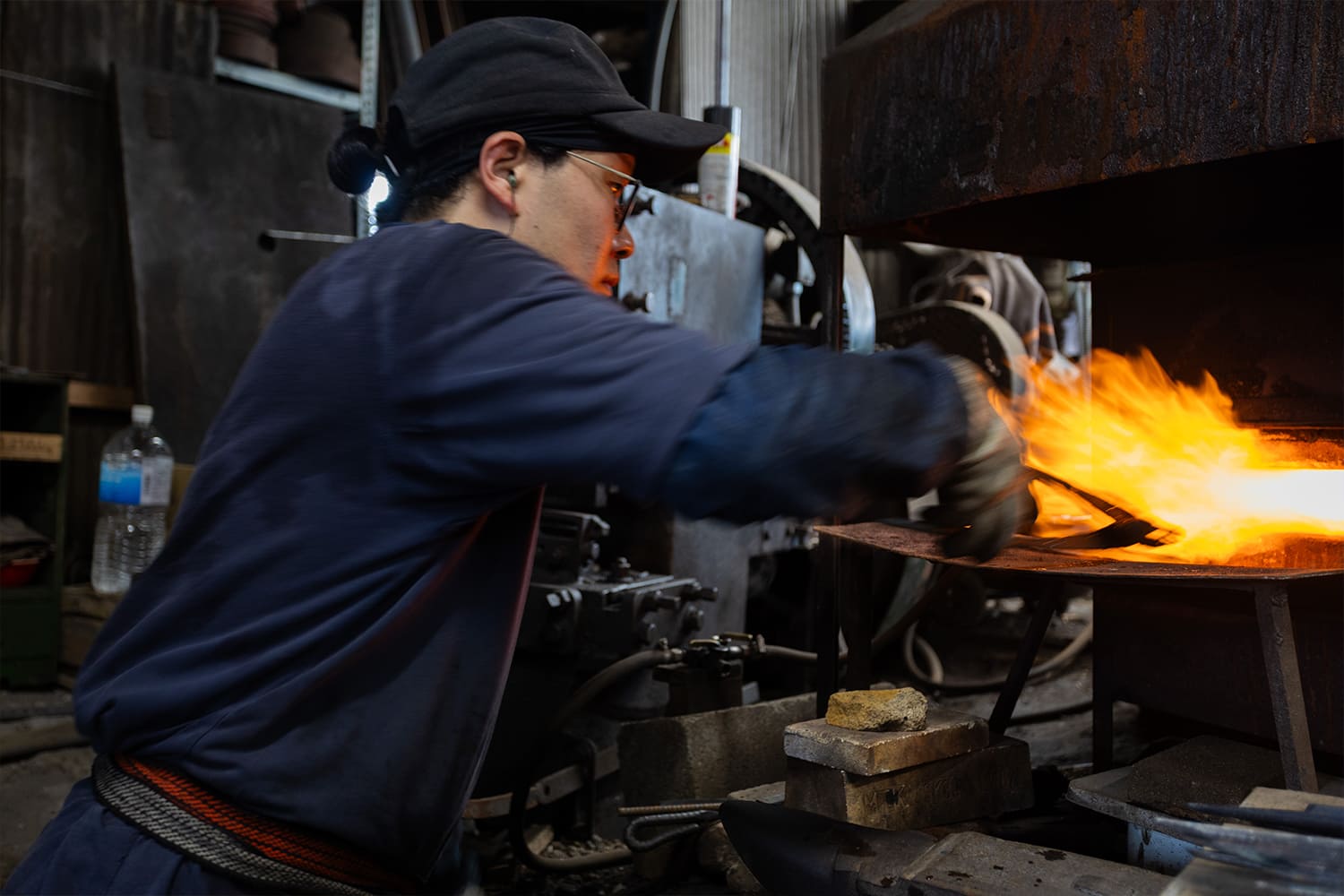 炉で真っ赤に焼く鉄を鍛える職人の姿 