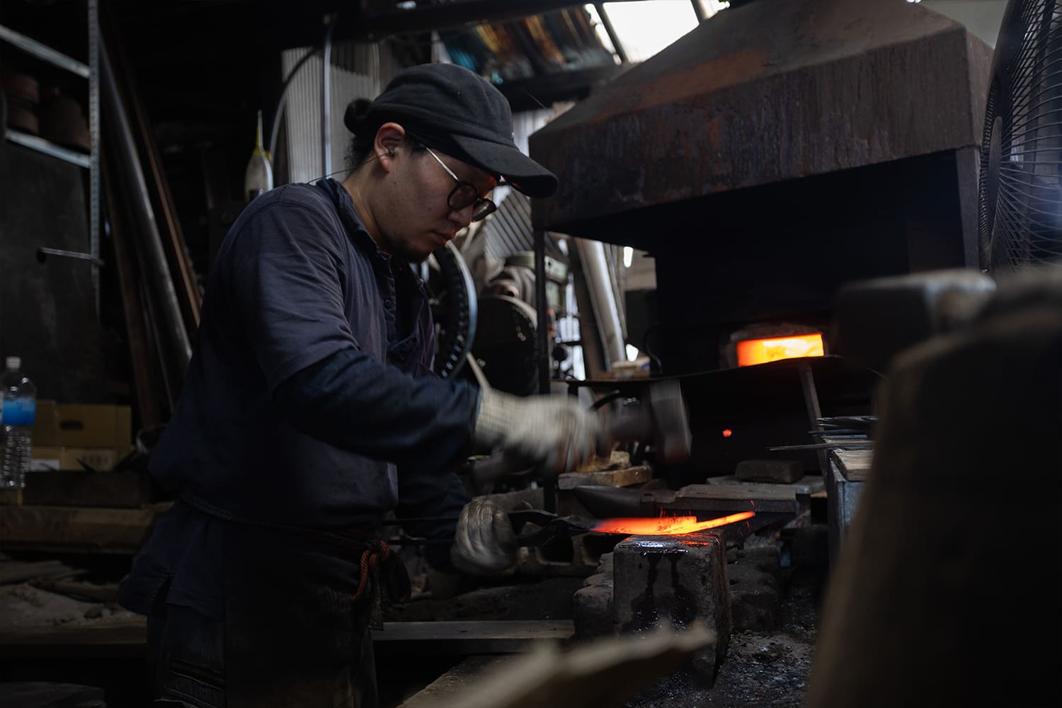 ハンマーで赤熱鋼を鍛える工房の職人 