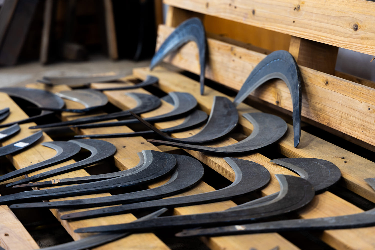 打ち出し途中の鎌が並ぶ鍛冶工房の風景 