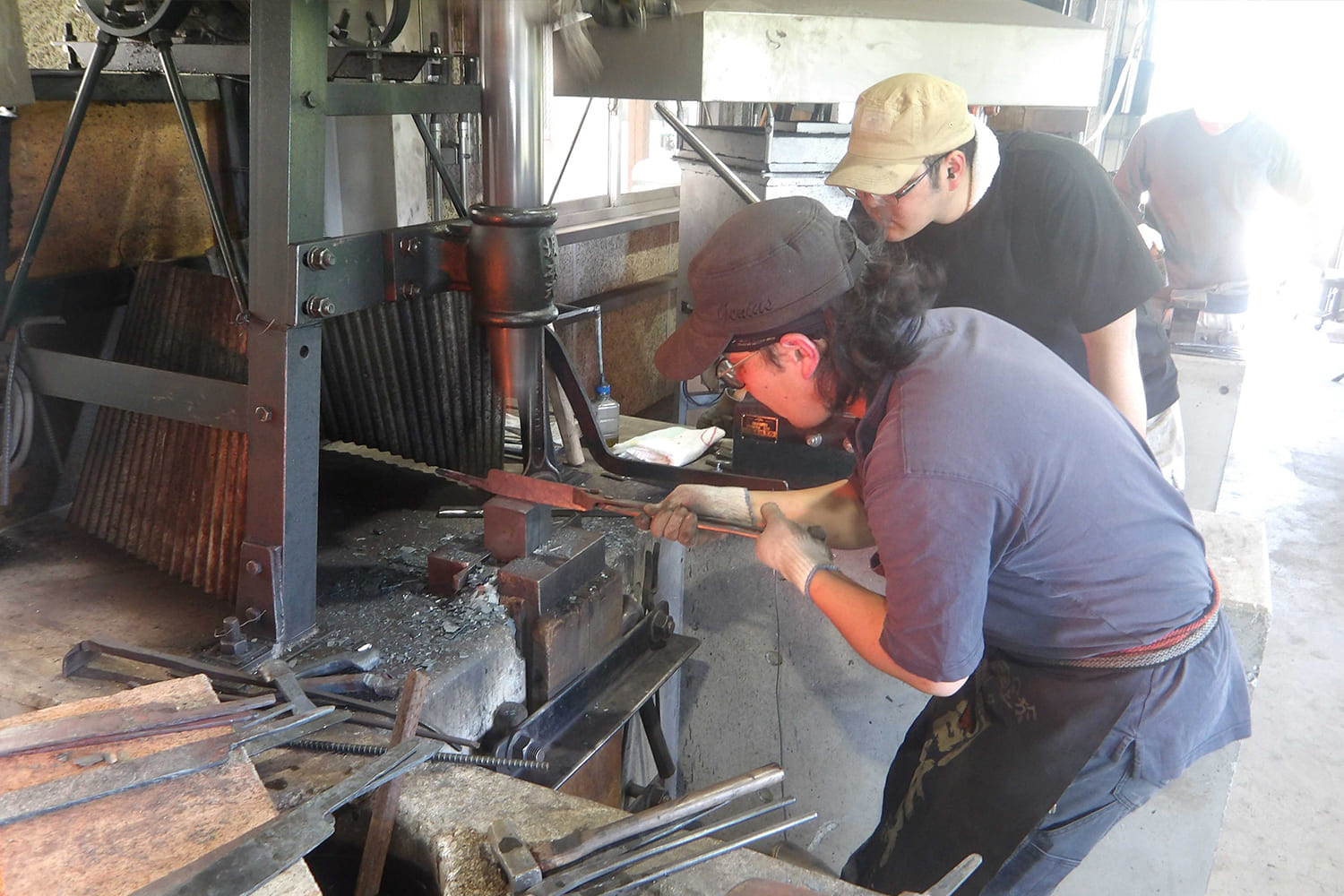 鍛造技術を学ぶ受講生の実技指導の様子