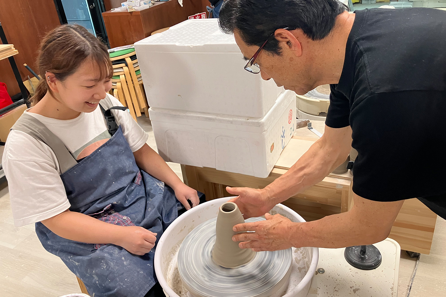 陶器を作成中の女性と教える男性
