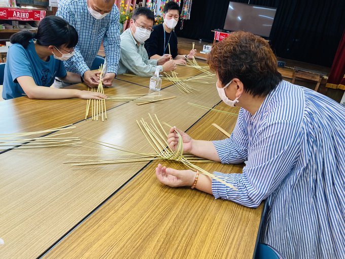 参加者が栗山さんに教えてもらいながら四波海かごを作成している光景