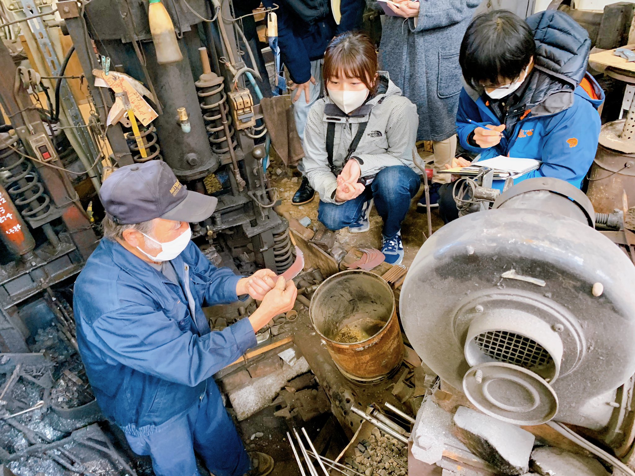 石田打刃物製作所で打刃物の製作を参加者が見学している様子
